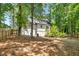 Expansive fenced backyard with mature trees, and back exterior view of the home at 944 Pine Ridge Dr, Stone Mountain, GA 30087