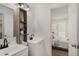 Bright bathroom featuring double sinks, rustic storage, and a view into an airy bedroom at 944 Pine Ridge Dr, Stone Mountain, GA 30087