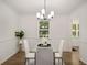 Stylish dining room features a modern light fixture and sleek glass table and hardwood floors at 944 Pine Ridge Dr, Stone Mountain, GA 30087