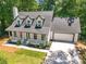 Aerial shot of an exterior highlighting a well-manicured lawn and Cape Cod-style home with a two-car garage at 944 Pine Ridge Dr, Stone Mountain, GA 30087