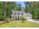 Landscaped front yard view of a Cape Cod-style home with dormer windows and a covered front porch at 944 Pine Ridge Dr, Stone Mountain, GA 30087