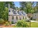 Exterior view of a charming Cape Cod-style home with a covered front porch and mature landscaping at 944 Pine Ridge Dr, Stone Mountain, GA 30087