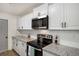 Updated kitchen features white cabinets, granite counters, stainless appliances, and modern hardware at 944 Pine Ridge Dr, Stone Mountain, GA 30087