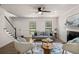 Inviting living room with staircase, fireplace, ceiling fan, and abundant natural light at 944 Pine Ridge Dr, Stone Mountain, GA 30087