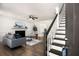 Inviting living room with a modern fireplace, stylish seating, and a view of the entryway stairs at 944 Pine Ridge Dr, Stone Mountain, GA 30087