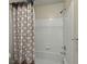 Clean bathroom with white tile, shower head, and patterned shower curtain at 4106 Chastain Park Ne Ct, Atlanta, GA 30342