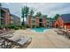 Beautiful community pool surrounded by lounge seating and brick apartment buildings at 4106 Chastain Park Ne Ct, Atlanta, GA 30342