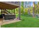 Inviting backyard with a hot tub, seating area, lush lawn, and mature trees for relaxation at 440 Laurian Nw Way, Kennesaw, GA 30144