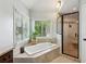 Bathroom featuring soaking tub with tile surround, window, and glass shower at 440 Laurian Nw Way, Kennesaw, GA 30144