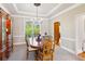 Formal dining room with tray ceiling, elegant chandelier, and a wooden china cabinet, creating a refined ambiance at 440 Laurian Nw Way, Kennesaw, GA 30144