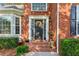 Close-up of an inviting front entrance featuring brick steps, wreath, and manicured hedges at 440 Laurian Nw Way, Kennesaw, GA 30144