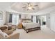 Spacious main bedroom featuring tray ceiling, ceiling fan, sitting area, and ensuite bath at 440 Laurian Nw Way, Kennesaw, GA 30144