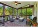 Relaxing screened porch with wicker furniture, ceiling fan, and views of the surrounding greenery at 440 Laurian Nw Way, Kennesaw, GA 30144