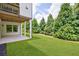 Large backyard features mature evergreens, green grass, and covered patio at 4992 Concert Ln, Marietta, GA 30066