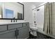 Bathroom with black fixtures, gray vanity, and tiled shower with curtain at 4992 Concert Ln, Marietta, GA 30066
