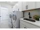 Bright laundry room features modern appliances, plenty of cabinet space, and quartz countertops at 4992 Concert Ln, Marietta, GA 30066