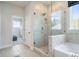 Bathroom featuring a soaking tub, glass shower, and elegant tile work at 5315 Trescott Path, Cumming, GA 30028