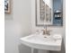 Bathroom with a pedestal sink, modern faucet, decorative mirror, and stylish wall art at 5315 Trescott Path, Cumming, GA 30028