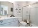 Well-lit bathroom featuring a shower, toilet, and white vanity with a framed mirror at 5315 Trescott Path, Cumming, GA 30028