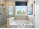 Bright bathroom featuring a soaking tub, glass shower, and window with a view at 5315 Trescott Path, Cumming, GA 30028