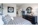 Bedroom featuring a full-sized bed, a circular mirror, and a black dresser with light fixtures at 5315 Trescott Path, Cumming, GA 30028