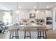 Modern kitchen with a large island, pendant lighting, stainless appliances, and white cabinetry at 5315 Trescott Path, Cumming, GA 30028