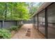 Screened porch on home exterior with gravel and lush landscaping, creating a serene outdoor space at 76 Forrest Pl, Atlanta, GA 30328