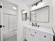 Bright bathroom with a black-framed mirror, white vanity and black and white tiled floor at 76 Forrest Pl, Atlanta, GA 30328