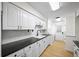 Eat-in kitchen features white cabinets, black countertops and stainless appliances, plus laundry area at 76 Forrest Pl, Atlanta, GA 30328