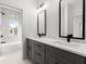 Elegant bathroom with double sinks, sleek mirrors, gray cabinets, and a tiled shower/tub combo at 988 Mcdaniel Sw St, Atlanta, GA 30310