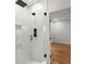 Contemporary bathroom featuring a tiled shower, glass door, and black fixtures, with a view to the bedroom at 988 Mcdaniel Sw St, Atlanta, GA 30310