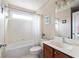 Bright bathroom featuring a tub with shower, a dark wood vanity with sink, a toilet, and a window for natural light at 207 Wesley Ne Ave, Atlanta, GA 30307