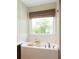 Bright bathroom featuring a soaking tub with a window and natural light at 207 Wesley Ne Ave, Atlanta, GA 30307