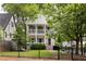 Inviting two-story home with double porches, blue shutters, a well-manicured lawn, and mature trees at 207 Wesley Ne Ave, Atlanta, GA 30307