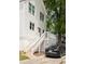 Rear view of a home featuring a white exterior, a backyard deck, stairs leading up to the deck, and a black car charging at 207 Wesley Ne Ave, Atlanta, GA 30307