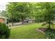 View of a well-manicured front yard with a grassy lawn, landscaping, an iron fence, and mature trees at 207 Wesley Ne Ave, Atlanta, GA 30307