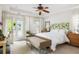 Light-filled main bedroom with French doors, a woven bench, and an elegant floral headboard at 207 Wesley Ne Ave, Atlanta, GA 30307