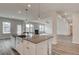 Modern kitchen with white cabinets, quartz counters, stainless steel appliances, island, wood floors and breakfast bar at 242 Linford Dr, Locust Grove, GA 30248