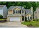 Two-story home featuring a two-car garage, and neutral siding, surrounded by well-maintained landscaping at 3454 Benthollow Ln, Duluth, GA 30096