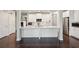 Modern kitchen featuring a center island, stainless steel appliances, white cabinets, and sleek hardwood floors at 3949 Glenview Club Ln, Duluth, GA 30097