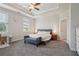 Bright main bedroom features a tray ceiling, ceiling fan, and plush carpet at 3949 Glenview Club Ln, Duluth, GA 30097