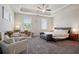 Spacious bedroom features a sitting area, ceiling fan, and tray ceiling at 3949 Glenview Club Ln, Duluth, GA 30097