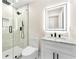 Modern bathroom features a glass shower and vanity with marble countertop and illuminated mirror at 4043 Chedworth Way, Stone Mountain, GA 30083