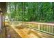 Outdoor wooden deck surrounded by lush greenery and tall trees, creating a serene and private space at 4043 Chedworth Way, Stone Mountain, GA 30083