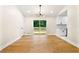 Light-filled dining room with modern lighting, hardwood floors, and easy access to the outdoor deck and kitchen at 4043 Chedworth Way, Stone Mountain, GA 30083