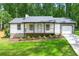 Charming renovated home featuring a welcoming porch and attached garage, all nestled on a lush green lot at 4043 Chedworth Way, Stone Mountain, GA 30083