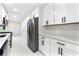 Modern kitchen with white cabinets, stainless steel appliances, marble countertops, and bright tile floors at 4043 Chedworth Way, Stone Mountain, GA 30083