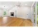 Bright living room featuring hardwood floors, stylish lighting, a stone fireplace, and large windows with a view at 4043 Chedworth Way, Stone Mountain, GA 30083