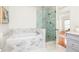 Bright bathroom features a soaking tub with gray and white marble and a glass enclosed walk-in shower at 513 Boulevard Se, Atlanta, GA 30312