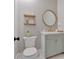Charming powder room features stylish wallpaper, decorative shelves, round mirror, and a vanity sink at 1421 Hendon Rd, Woodstock, GA 30188